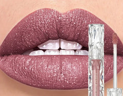 Lip gloss with glittery pink shade applied to lips, next to product packaging.