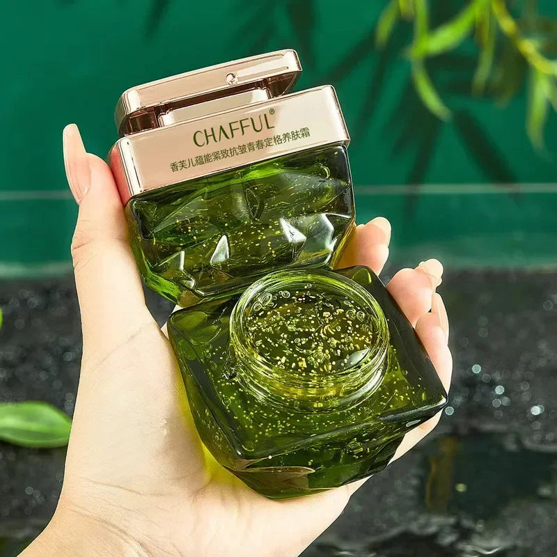Hand holding a green skincare product with 'CHAFFUL' branding against a blurred natural background