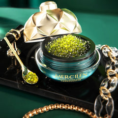 Cosmetic jar with green caviar-like substance and gold lid on a dark surface.