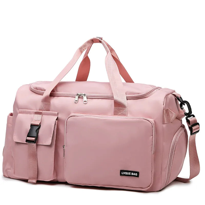 Pink duffel bag with multiple pockets and straps on a white background